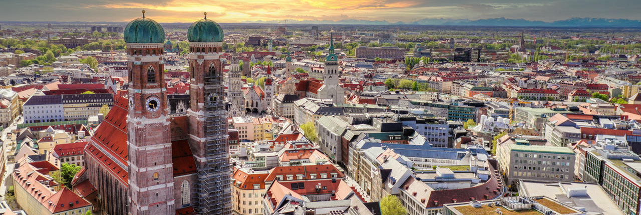 Blick von oben auf München mit den Frauentürmen im Hintergrund